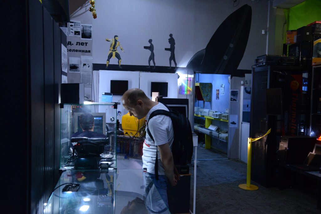 Основной зал Антимузея компьютеров в Екатеринбурге, посетитель рассматривает витрину с экспонатами